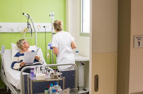 Infirmière auprès d'une patiente atteinte d'un cancer du sein, en séance de chimiothérapie ambulatoire dans un centre de cancérologie. 